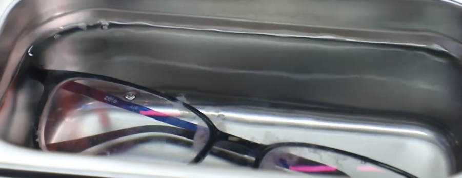 The ultrasonic cleaner is cleaning the glasses.