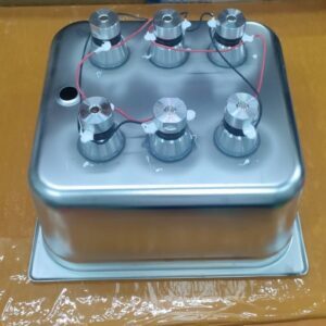 An unassembled ultrasonic cleaner with the ultrasonic transducers clearly attached to the bottom of the cleaning tank.